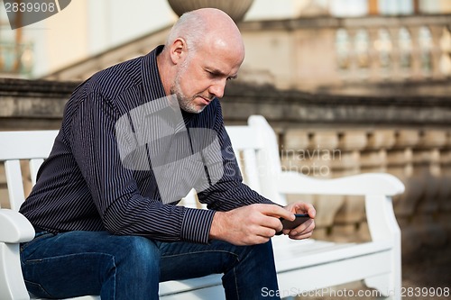 Image of Man checking a photo on his mobile phone