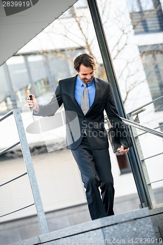 Image of Smiling businessman walking down stairs