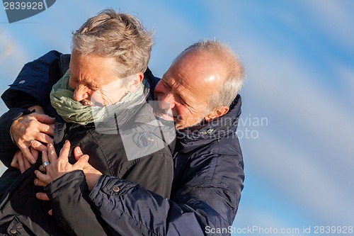 Image of Elderly couple embracing and celebrating the sun