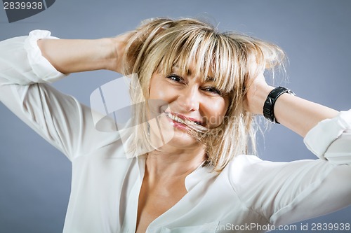 Image of Smiling confident middle-aged blond woman