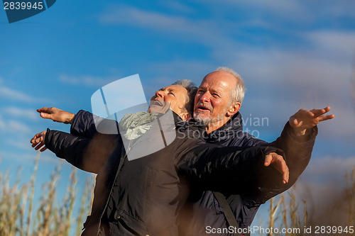 Image of Elderly couple embracing and celebrating the sun