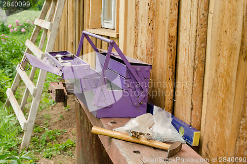 Image of purple toolbox hammer nail on wooden table outdoor 