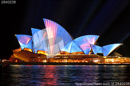 Image of Sydney Opera Hosue illuminated in blue and red motion strips