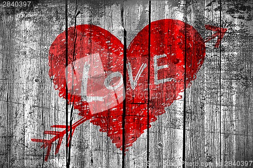 Image of Drawing of a heart with word "Love" on grunge wooden wall