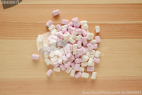 Image of Pink and white mini marshmallows on wood