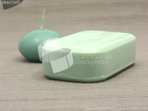 Image of Green soap and green candle on a  gray background