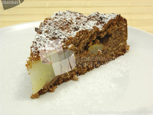 Image of One slice of pear cake on a white plate dusted with powder sugar