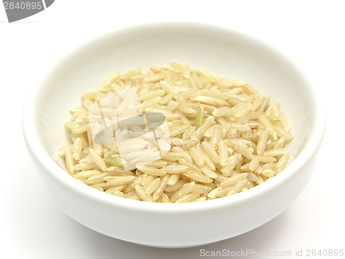 Image of Brown rice in a bowl of chinaware on a white background