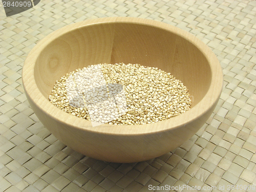 Image of Wooden bowl with quinoa on rattan underlay