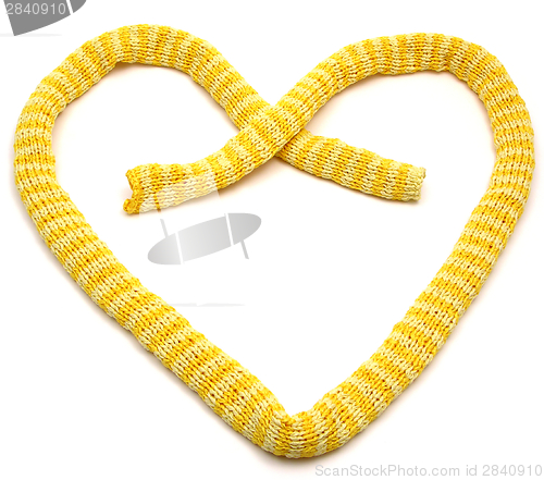 Image of Yellow striped knitting scarf arranged as heart on white