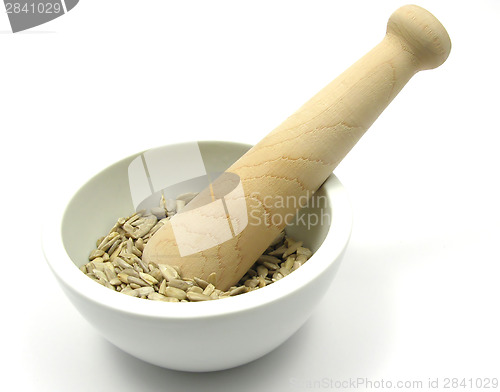 Image of Pestling sunflower seeds in a bowl of chinaware