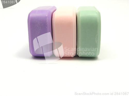 Image of Three colored soaps on a white background