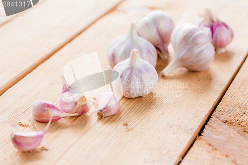 Image of raw garlic on a wooden plank