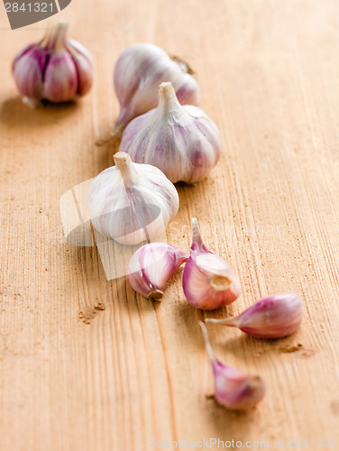 Image of raw garlic on a wooden plank