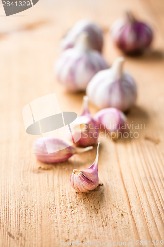 Image of raw garlic on a wooden plank