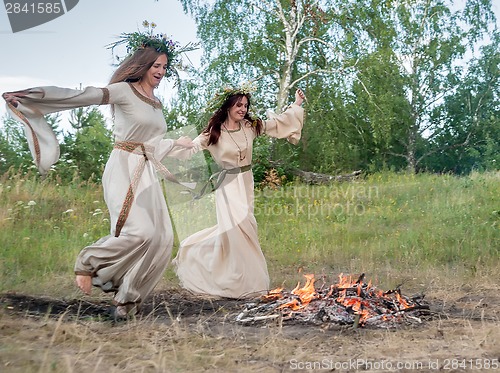 Image of Attractive women jumping through fire