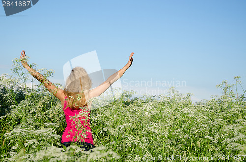 Image of young woman back view wild caraway meadow summer 