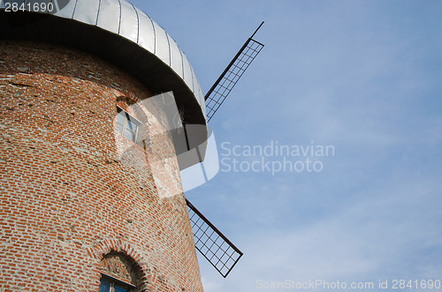 Image of side of rustic mill with window on sky background 