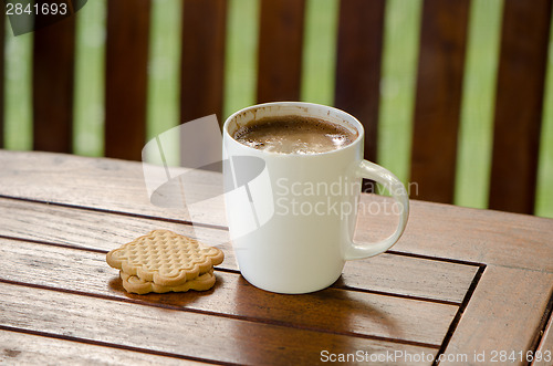 Image of Cup of hot coffee in white cup and cookie biscuit 