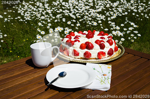 Image of Made table with strawberry cake and coffee cup