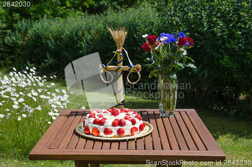 Image of Homemade strawberry cake on decorated table in garden