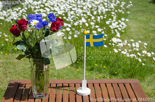 Image of Table with summer flowers and a swedish flag