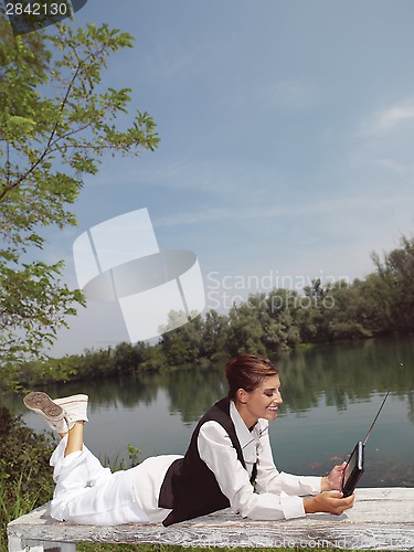 Image of a woman with laptop in park okj