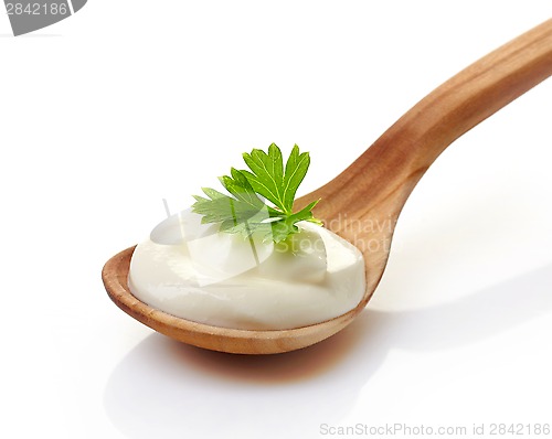 Image of sour cream in a wooden spoon