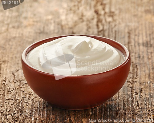 Image of cream in a brown ceramic bowl