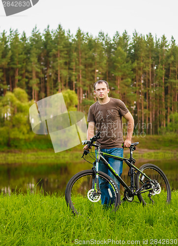 Image of Young man on the GT bicycle biking through a sunny countryside. 