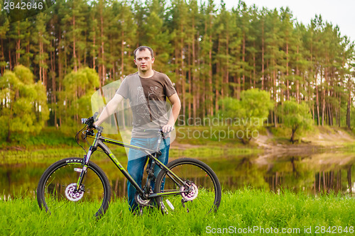 Image of Young man on the GT bicycle biking through a sunny countryside. 