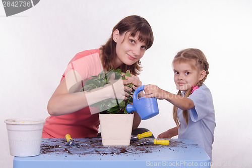 Image of Mom and daughter watering flower