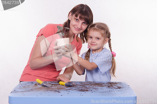 Image of Mom and daughter planted flower room in the pot