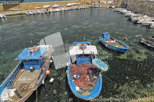 Image of Fisherman repairs his net on boat