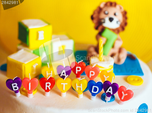 Image of Happy birthday written in candles on colorful background