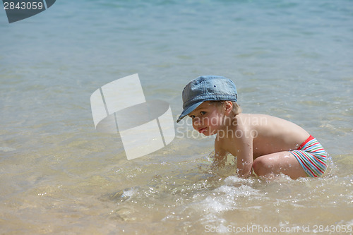 Image of Little boy playing in the sea