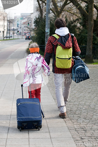 Image of brother and sister with suitcases