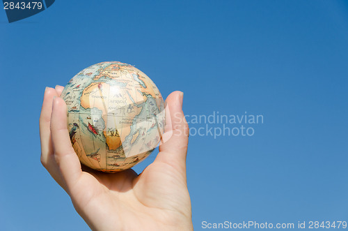 Image of earth globe model palm on blue background, Africa. 