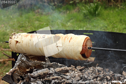 Image of cooking kurtos kalacs on camp fire