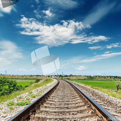 Image of rail road to horizon under deep blue sky