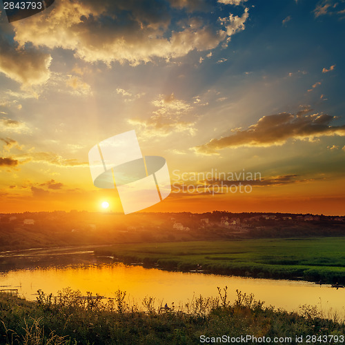 Image of dramatic orange sunset over river