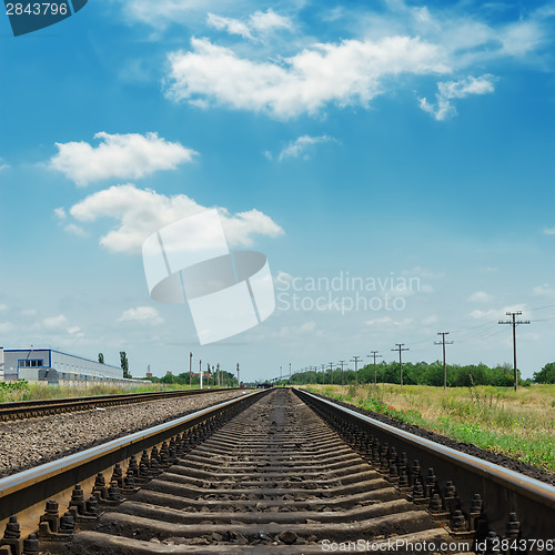 Image of railroad closeup and clouds in blue sky