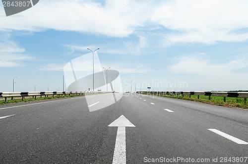 Image of white arrow on asphalt road