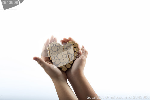 Image of Young hands giving wooden heart