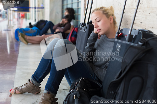 Image of Tired female traveler waiting for departure.