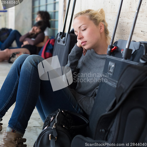 Image of Tired female traveler waiting for departure.