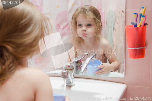 Image of Three year girl to rinse your mouth after brushing teeth