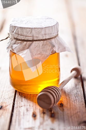 Image of full honey pot and honey stick