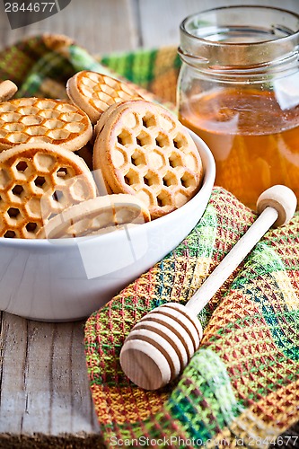 Image of fresh cookies in a bowl, tablecloth and honey