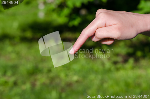 Image of womans hand with water drop on the end of finger  